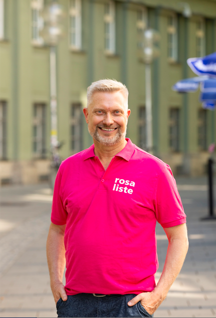 Bernd Müller mit Rosa-Liste-Shirt vor Feuerwehr-Ausfahrten